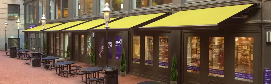 Yellow awnings over a restaurant's outdoor seating