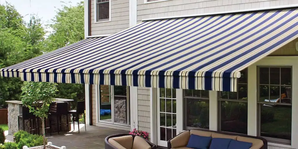 Navy and white striped retractable awning shading a back patio